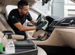 Technicien Wash&Check effectuant le nettoyage intérieur d'une voiture de flotte d'entreprise